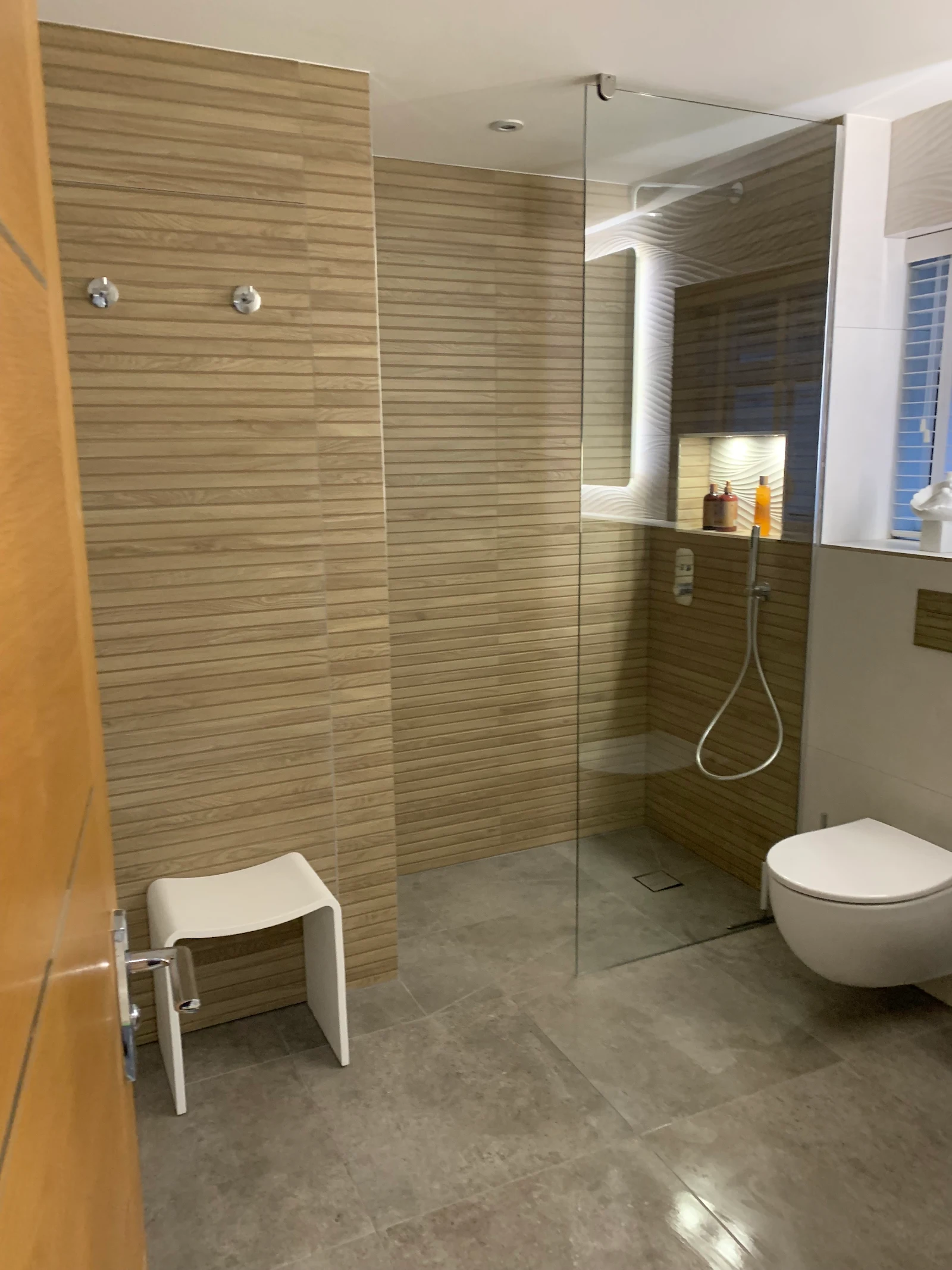 Wet-room style walk-in shower with wood-effect tiling and stone floor