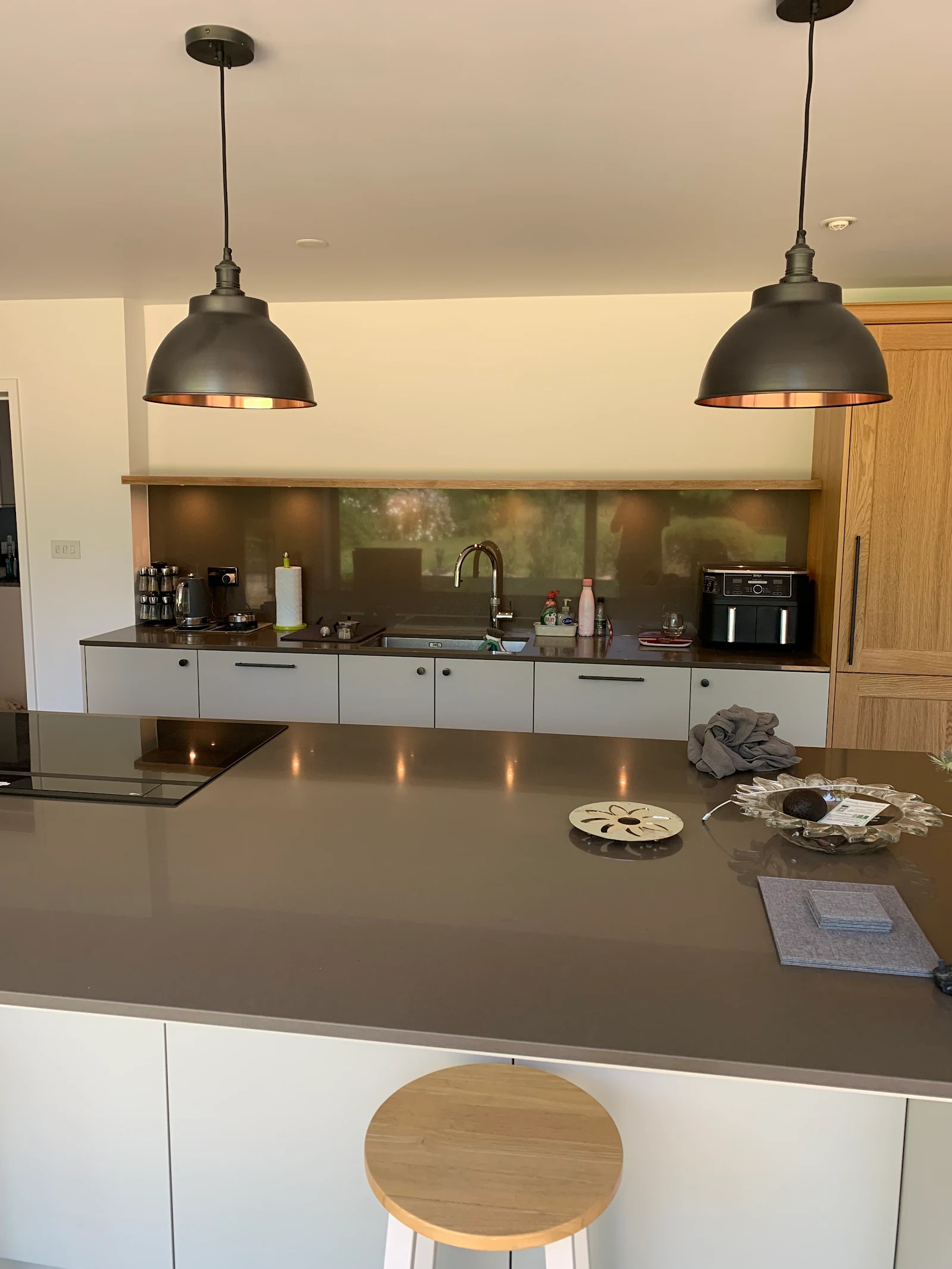Cream handleless kitchen with a grey island and pendant lighting