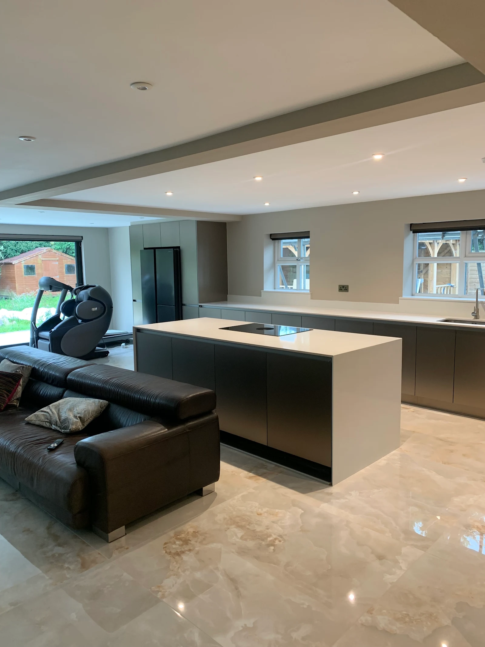 Open-plan grey kitchen with large island and polished marble floor
