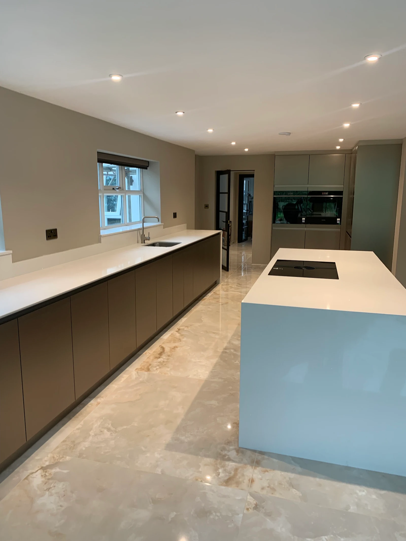 Expansive grey kitchen with twin islands and marble flooring